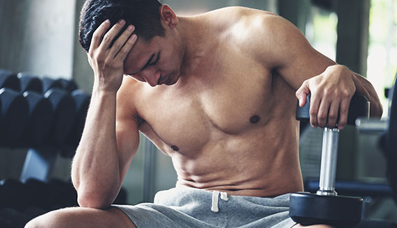Frustrated man with dumbbells